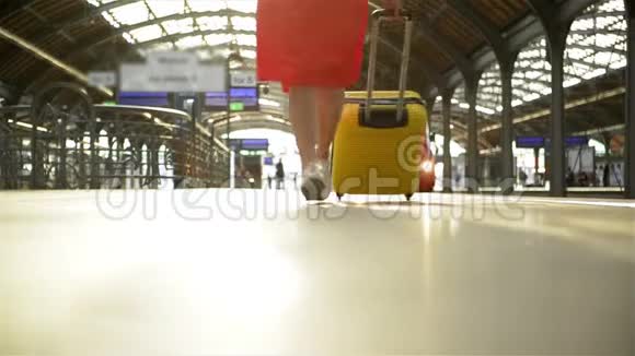 年轻的白种人女人带着手提箱跑着去赶火车然后火车就离开了车站视频的预览图