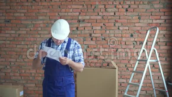 一个拿着建筑图的不懂理解的男建筑工人视频的预览图