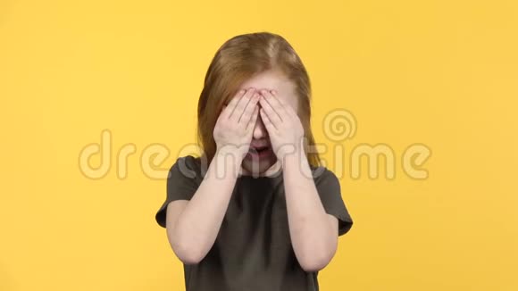 可爱的红头发的孩子玩得很开心用手遮住她的脸慢动作视频的预览图