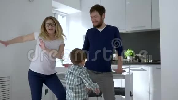 跳舞家庭休闲妈妈和爸爸和孩子在室内玩得开心视频的预览图
