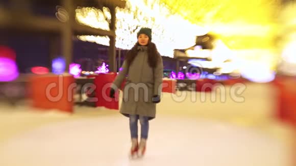 一个年轻女子站在开着的溜冰场上微笑着用手挥手视频的预览图