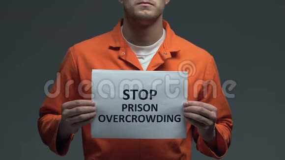 停止高加索囚犯手中纸板上的监狱过度拥挤用语视频的预览图