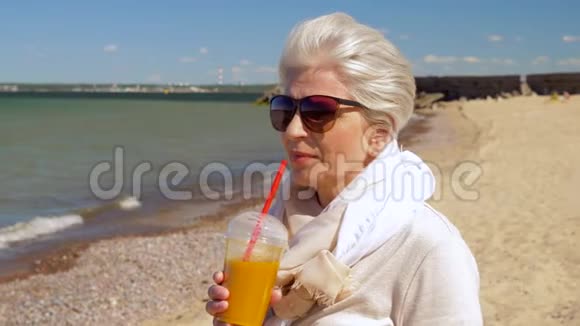 在夏日海滩喝奶昔的老妇人视频的预览图