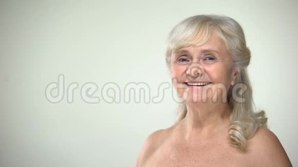 有魅力的老太太不喝酒微笑着对着镜头衰老的美容观念视频的预览图
