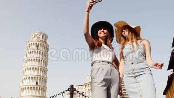 意大利比萨两个穿着睡衣的年轻女人站在比萨斜塔的背景上自拍视频的预览图
