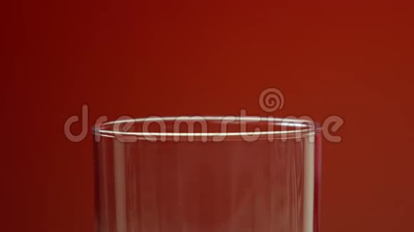 红色苏打水倒在玻璃里红色背景和气泡中心点最小模糊视频的预览图