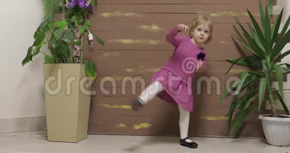 幼儿在花盆和木栅栏附近跳舞开心微笑视频的预览图