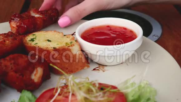 女用手蘸蕃茄酱炒鸡翅美味不健康的饭菜视频的预览图