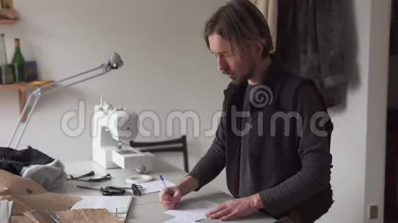 男裁缝在车间绘制创造性的服装草图视频的预览图