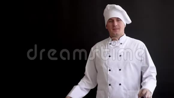 高级厨师戴厨师帽手指朝上黑色背景视频的预览图