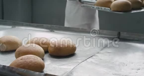 一家面包店的工厂把面包卸到了专门的架子上工人们穿着特别的白色制服视频的预览图
