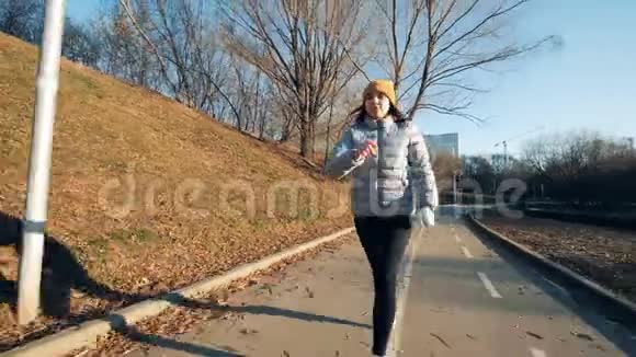 有一只机械手臂的年轻女士正沿着公园跑视频的预览图