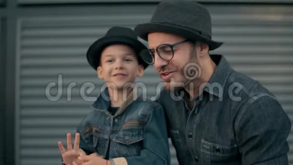 爸爸和小儿子在户外玩耍的时候一边聊天一边微笑视频的预览图