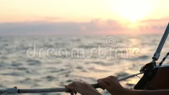 日落时分女性双手握着游艇上的绳子视频的预览图