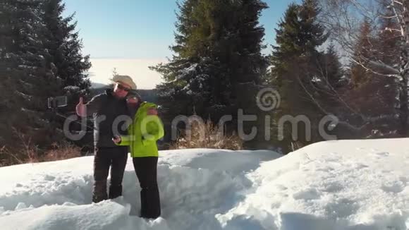 那个带着女孩的家伙在山里的冬林里拍了一张自拍视频的预览图