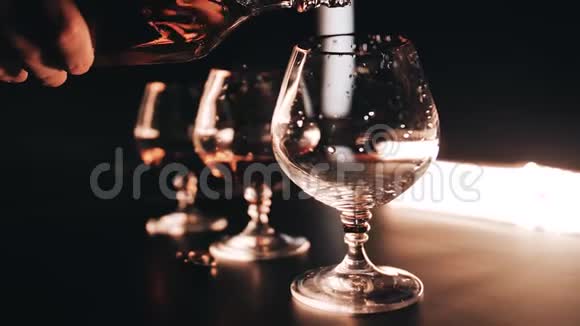 在桌子上从一个瓶子到一个玻璃的威士忌的特写镜头它很漂亮慢动作视频的预览图