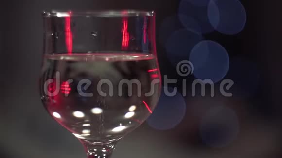 圣诞节新年假日在闪烁的彩灯背景下香槟杯中的气泡背景视频的预览图