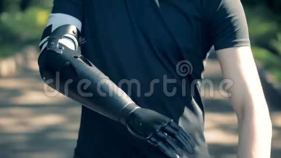 一个人正用一只健康的手臂横过他的人工手臂人类半机器人概念视频的预览图