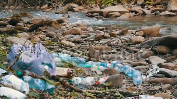 山快净溪落石岸边里面有垃圾塑料瓶袋子环境中的人的因素视频的预览图