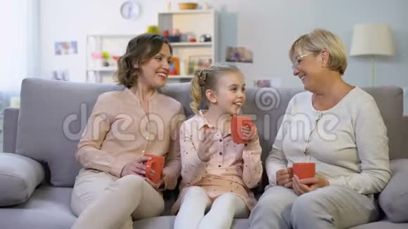女性家庭成员坐在家里的沙发上一起喝茶视频的预览图
