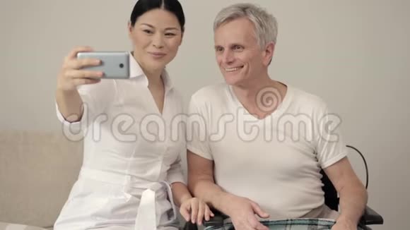 一位亚洲护士和她的轮椅病人服用自拍视频的预览图