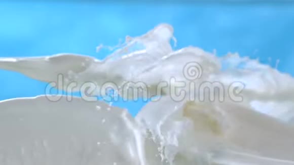 在蓝色背景特写镜头上以1500fps高速喷射牛奶和溅水视频的预览图
