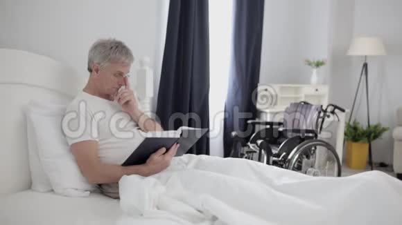 在医院里一个头发灰白的成年人躺在贵宾室的床上视频的预览图