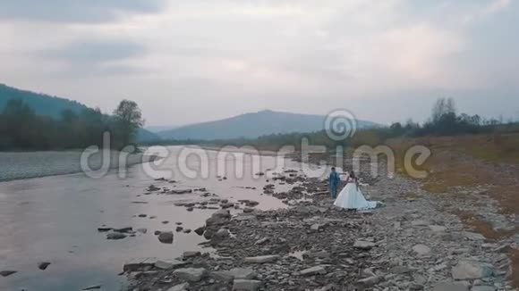 新婚夫妇站在河边新郎和新娘审判意见视频的预览图