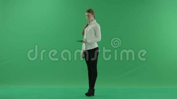 年轻的女商人正在她的平板电脑上聊天她穿着正式的衣服白色衬衫和黑色裤子站在上面视频的预览图