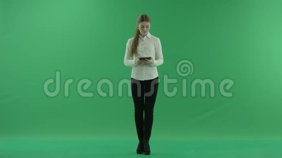 年轻的女商人正在她的平板电脑上聊天她穿着正式的衣服白色衬衫和黑色裤子站在上面视频的预览图