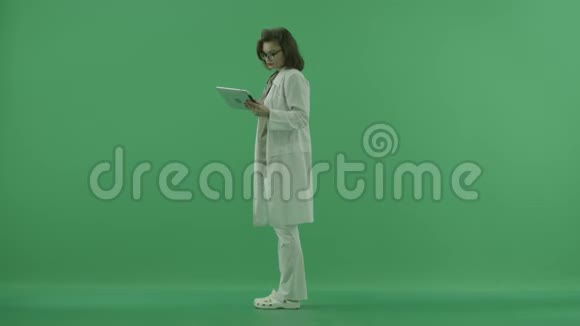 医生向左看在绿色屏幕上检查药片上的东西视频的预览图
