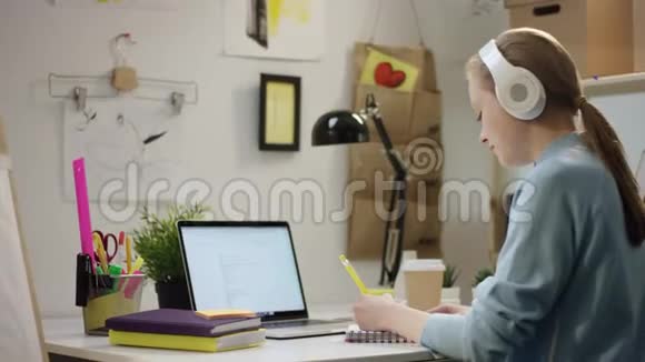 年轻女子在学习时听音乐视频的预览图