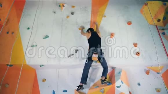 爬在巨石墙上的雄性登山者被放大和缩小视频的预览图