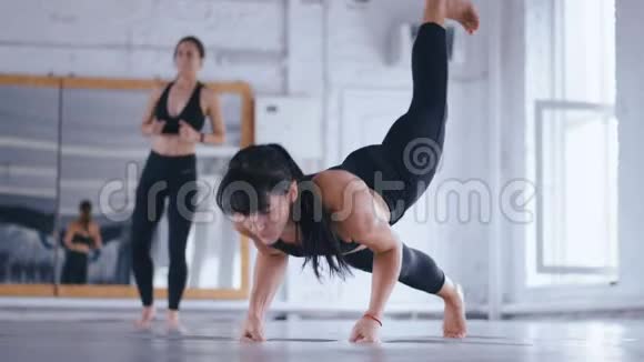 运动型美女在交叉健身馆的地板上做俯卧撑女运动员在健身房锻炼交叉装备视频的预览图