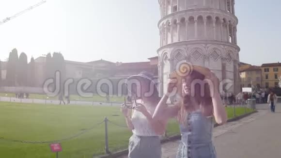 意大利比萨在一个晴朗的日子里两个年轻的女人走在比萨斜塔的背景上视频的预览图