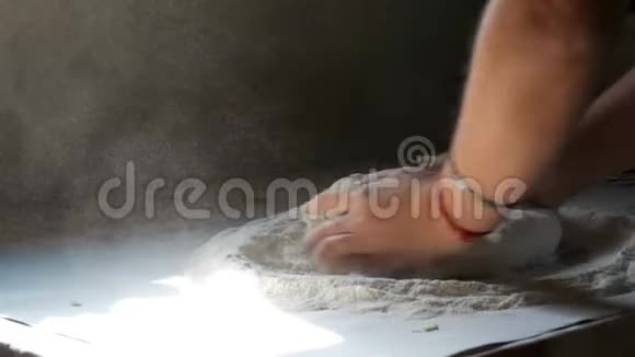 女人的手在村里的老式厨房里揉面团一缕阳光洒在面团和面粉上视频的预览图