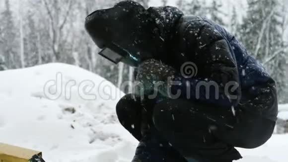 人在冬季室外焊接金属零件视频的预览图