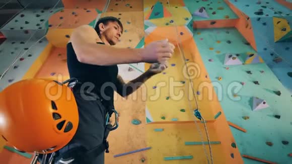 一个人正准备爬一堵健身房的墙把他的手弄得粉身碎骨视频的预览图