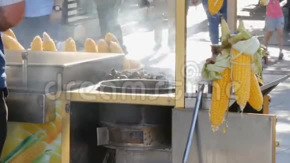 街亭柜台上的新鲜玉米街头食品卖家在一个城市街头向顾客连续出售煮玉米视频的预览图