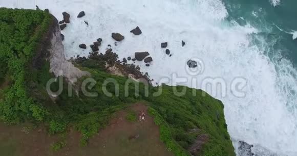 海滩悬崖4k的泡沫海浪和岩石海洋的空中镜头视频的预览图
