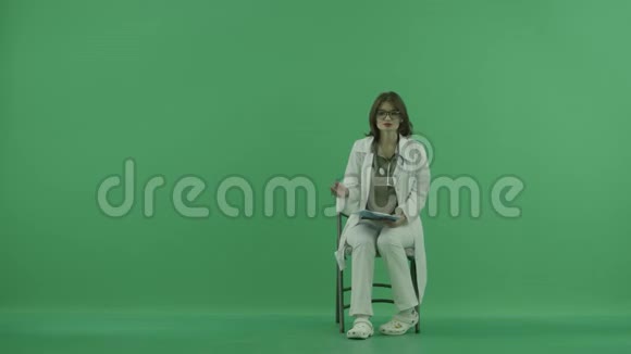 医生坐在椅子上在绿色的屏幕上讲述一些事情视频的预览图