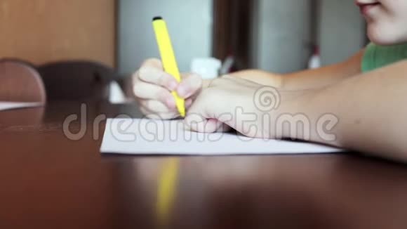一个男孩坐在书桌前用白纸上的彩色记号笔画素描视频的预览图