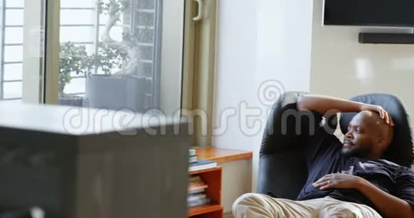 男人在舒适的家中靠椅子放松视频的预览图