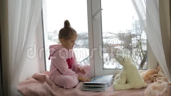 女孩给玩具熊看书视频的预览图