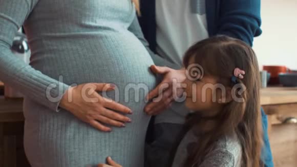 小女儿抱着母亲怀孕的肚子视频的预览图