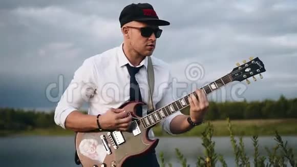 他在湖边弹吉他音乐和自然视频的预览图
