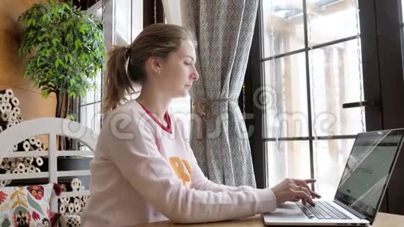 年轻女子在一家小咖啡馆里用笔记本视频的预览图