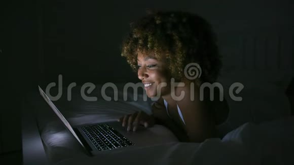微笑的女人在黑暗中聊天视频的预览图