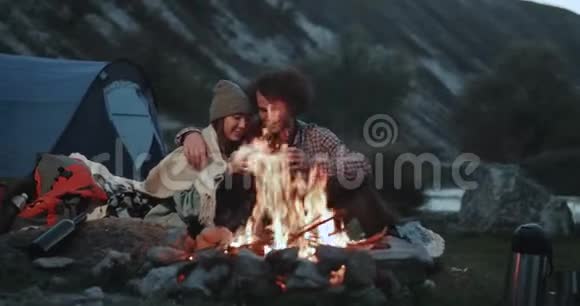 不错的夫妇在露营时参加多场比赛在篝火旁喝一些金属杯的热饮料视频的预览图