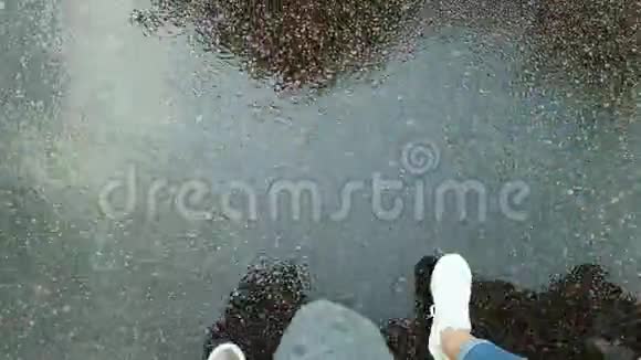 拍摄的男女双腿灰湿地从雨中行走的镜头视频的预览图